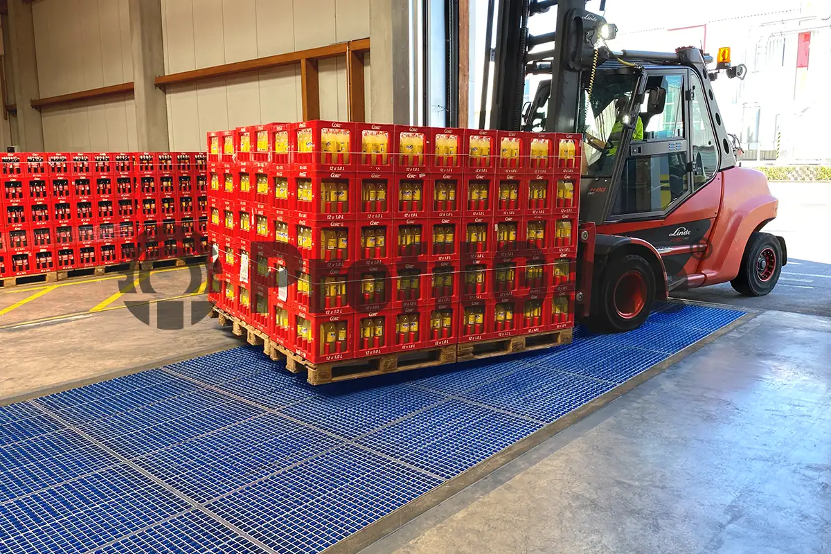 Roter Gabelstapler, mit roten Getränkekisten beladen, fährt über eine blaue Sauberlaufzone