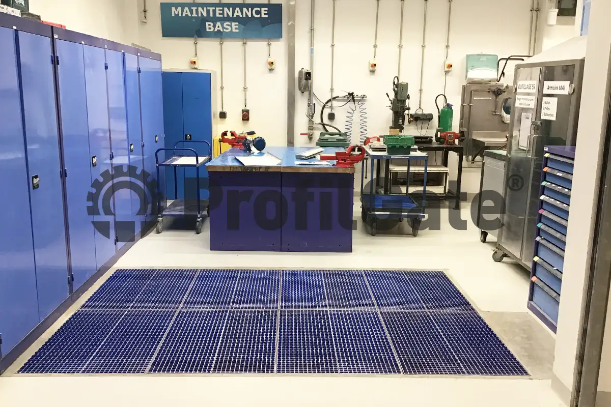 Blaue Sauberlaufzone vor einem Werkstattbereich und Arbeitsplätzen