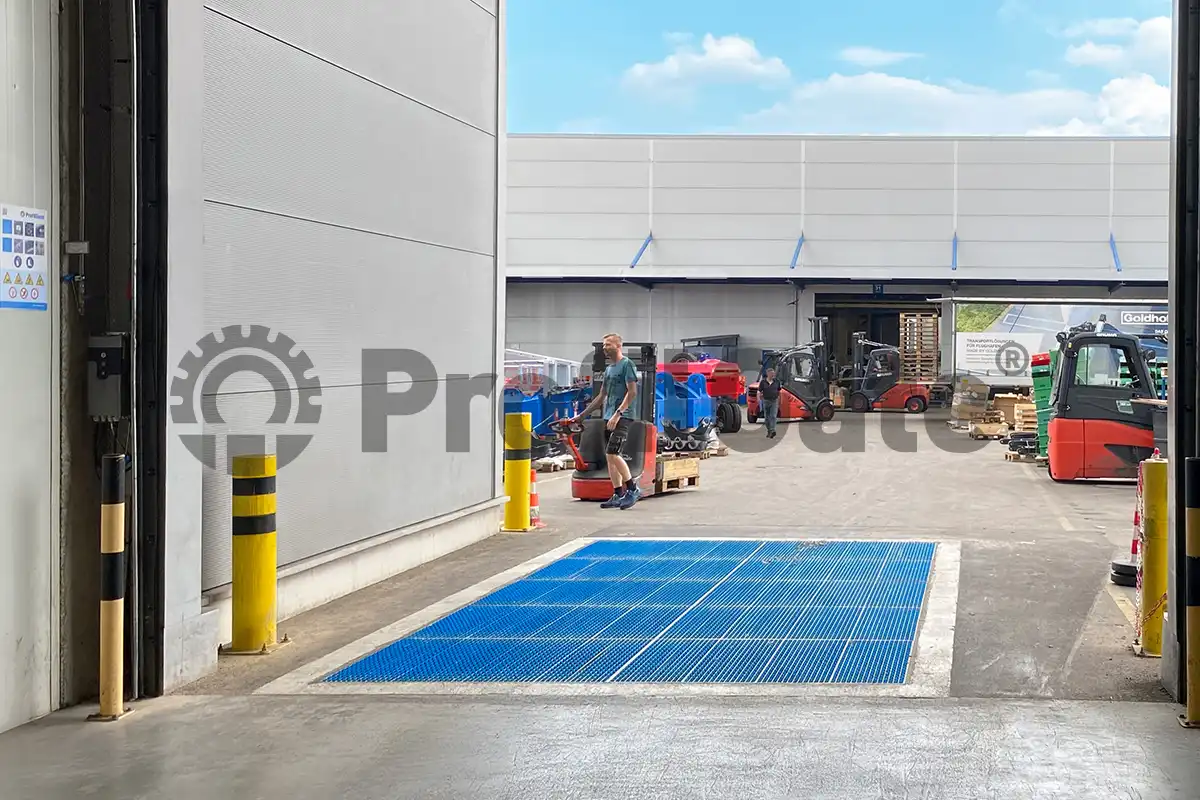 Im Eingangsbereich einer Industriehalle ist eine blaue Sauberlaufzone mit Gabelstapler im Hintergrund